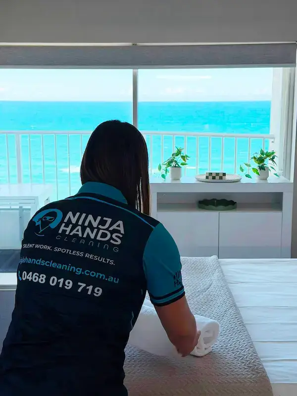 Ninja Hands cleaner making bed in ocean view apartment